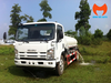 Xe bồn phun nước Isuzu cabin trắng nhìn từ góc trước, vòi bên hông đang xả nước