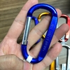 Tay người cầm nhiều móc khóa carabiner Coghlans nhiều màu móc vào nhau