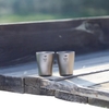 Ly Uống Rượu Keith Titanium Wine Cup 10ml hai ly trên bàn gỗ ngoài trời, nền tối