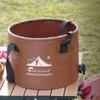 Xô nước gấp gọn Flextail Flex Bucket đặt trên bàn cắm trại ngoài trời cùng vài quả cà chua